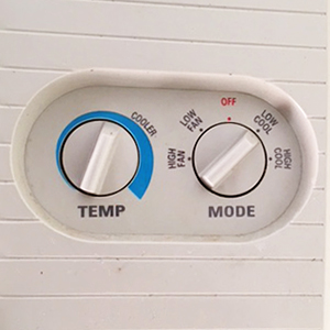 AC units with dials should be set just right of center on the Temp (left) dial, and at Low/Cool on the Mode (right) dial.