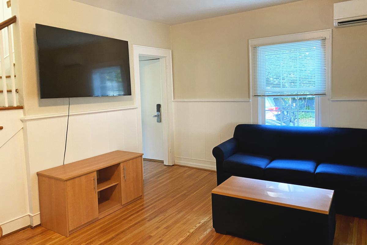 Recovery Housing living room with wooden floors, sofa, coffee table, and flat-screen TV