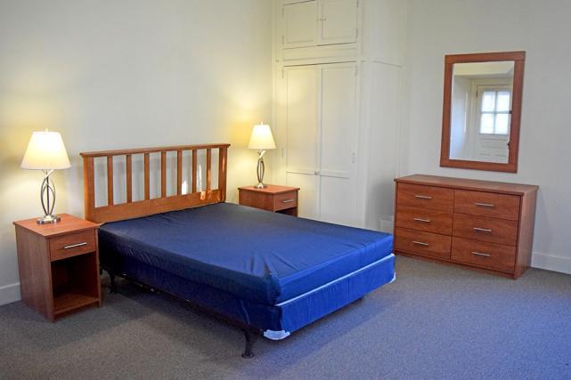 Bedroom includes a full-size bed, end tables, closets, and dressers