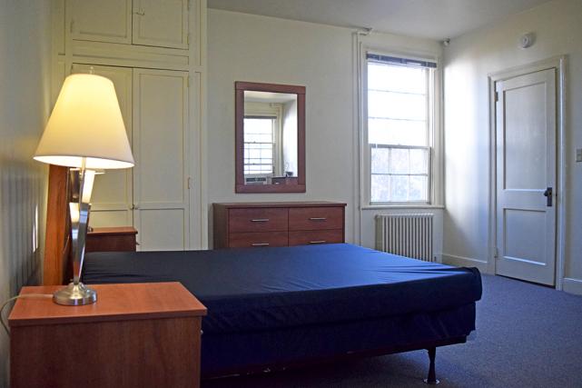 Bedroom includes a full-size bed, end tables, closets, and dressers