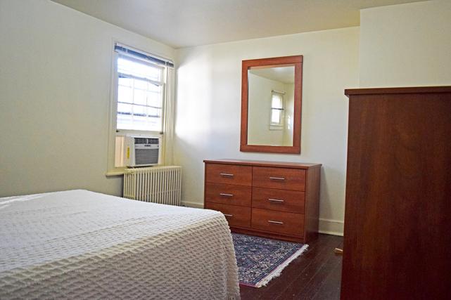 Bedroom includes a full-size bed, dressers, and wall mirror