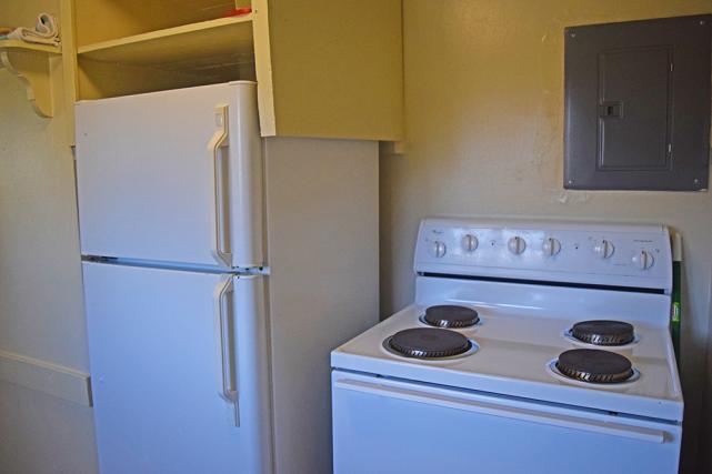 Kitchen includes stove and full-size refrigerator with freezer