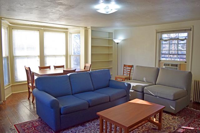 Living room includes a sofa and chairs, coffee and end tables, desk, and dining table and chairs