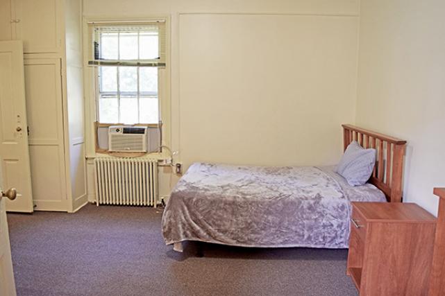Master bedroom includes full-size bed with linens, closet, dresser, and nightstands with lamps