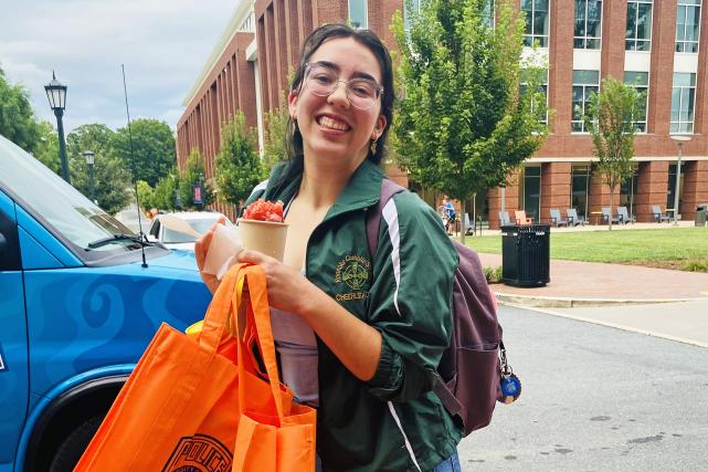 A second-year resident with a giveaway tote bag and Kona Ice