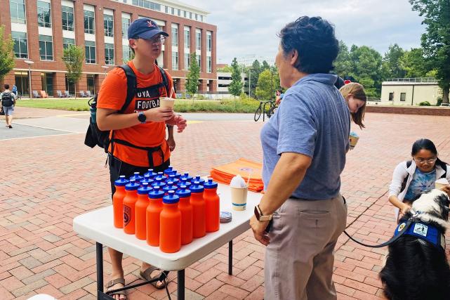 A second-year resident talking to UVA Police at a table of giveaways