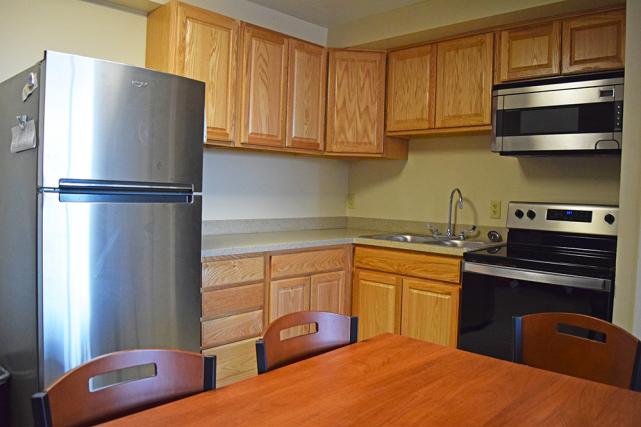 Kitchen with refrigerator, microwave, and stove